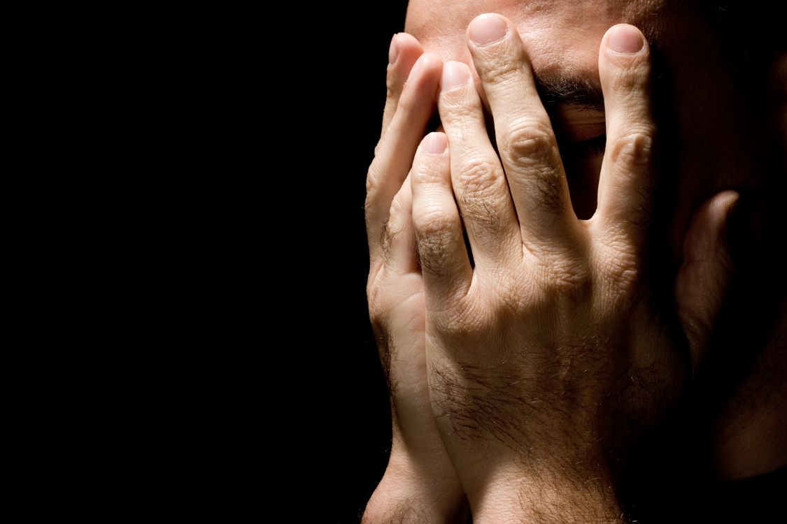 hands covering face in despair and sadness pain