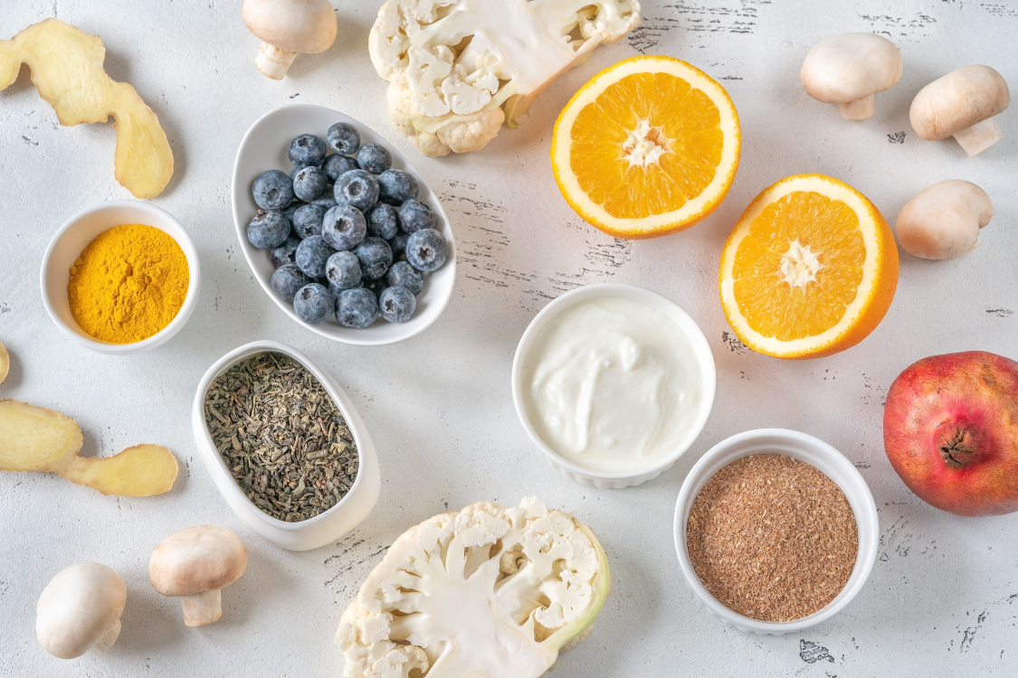 ingredients on a white table, ginger, blueberries, cauliflower, pomegranate, mushrooms, polyphenols
