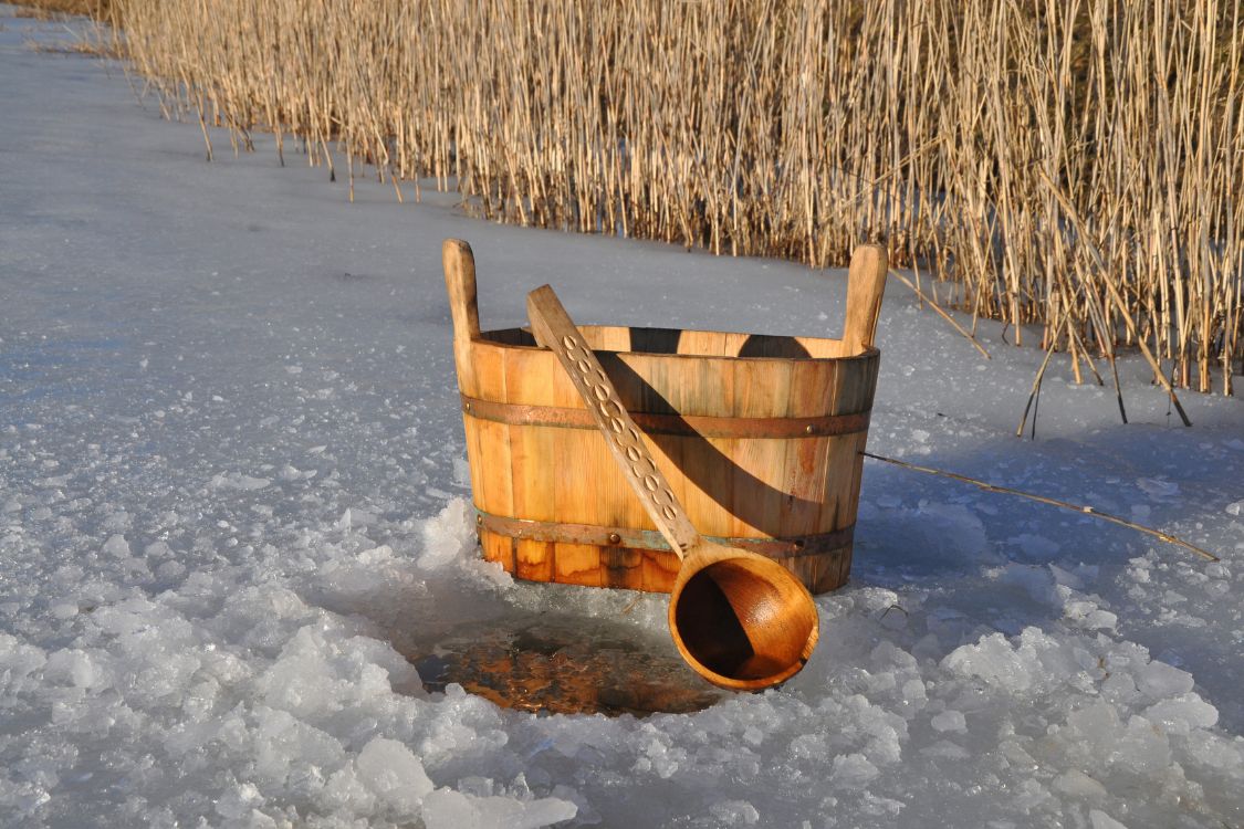 bucket of ice in the snow, placed next to a field in the sunshine